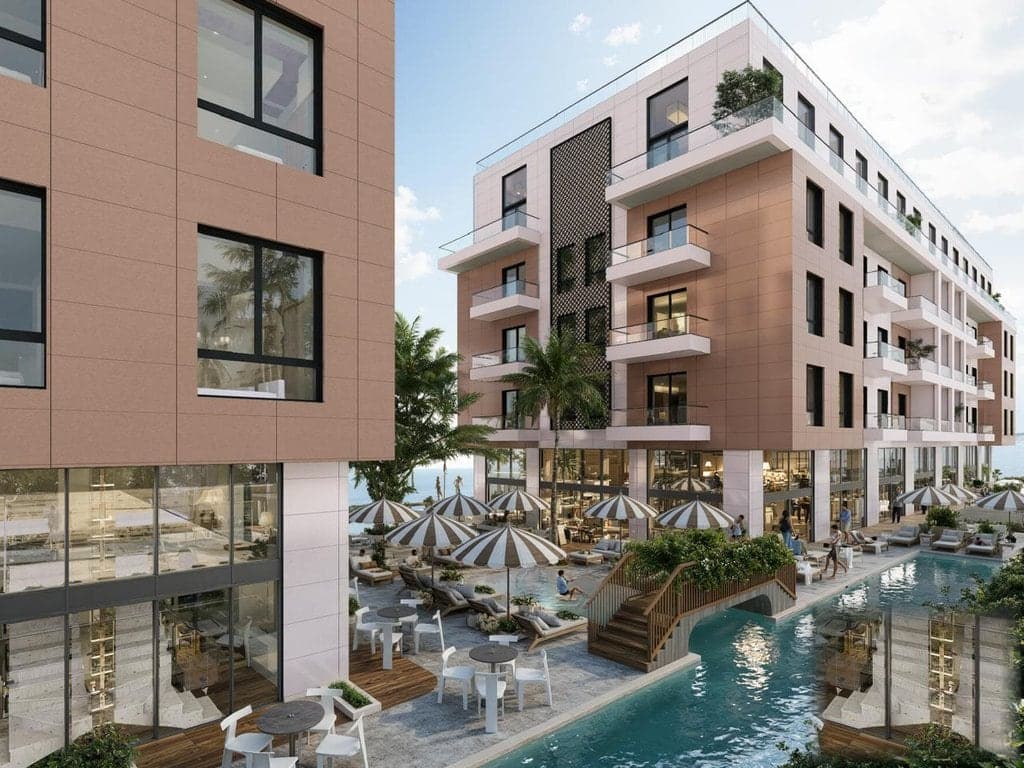Adria Residence — terracotta facade, ground-floor pool deck and shaded promenade, Qerret 200 m from the sea.